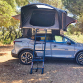 Vista panorámica de la tienda de techo Eclipse de Soplair abierta sobre un SUV en el bosque