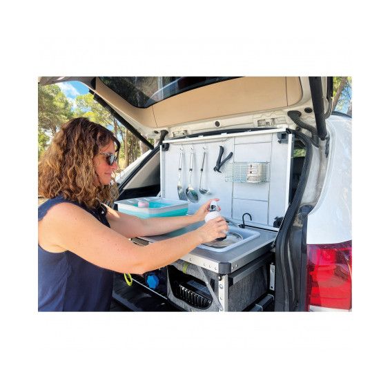 Mujer utilizando la palangana integrada del Kitch&Box Incasa en el maletero de un SUV blanco