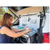 Mujer utilizando la palangana integrada del Kitch&Box Incasa en el maletero de un SUV blanco