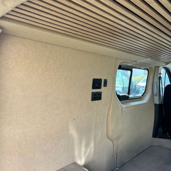 Beige automotive carpet walls converted van